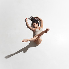 Image showing Young beautiful dancer in beige dress dancing on gray background