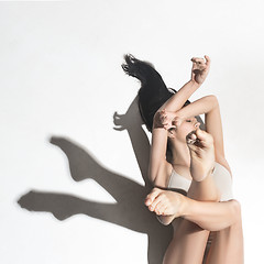 Image showing Young beautiful dancer in beige dress dancing on gray background