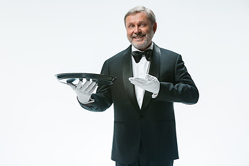 Image showing Senior waiter holding tray