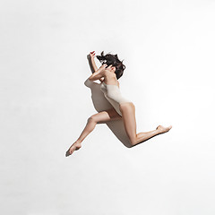 Image showing Young beautiful dancer in beige dress dancing on gray background