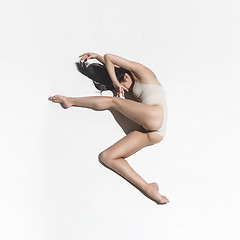 Image showing Young beautiful dancer in beige dress dancing on gray background