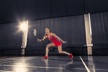 Image showing Young woman playing badminton at gym