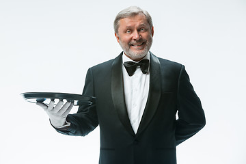 Image showing Senior waiter holding tray