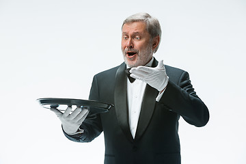 Image showing Senior waiter holding tray