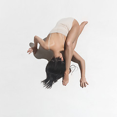 Image showing Young beautiful dancer in beige dress dancing on gray background