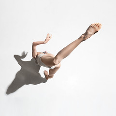 Image showing Young beautiful dancer in beige dress dancing on gray background