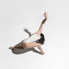 Image showing Young beautiful dancer in beige dress dancing on gray background