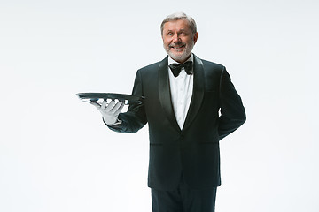 Image showing Senior waiter holding tray