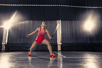 Image showing Young woman playing badminton at gym