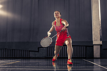 Image showing Young woman playing badminton at gym