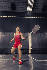 Image showing Young woman playing badminton at gym