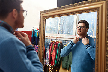 Image showing man looking at mirror at vintage clothing store