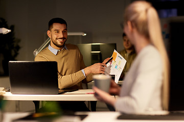 Image showing colleagues discussing project at night office