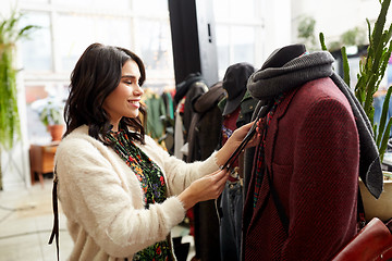 Image showing happy woman choosing clothes at clothing store