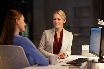 Image showing happy businesswomen talking late at night office