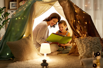 Image showing happy family reading book in kids tent at home