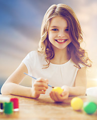 Image showing happy girl coloring easter eggs
