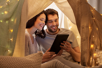 Image showing happy couple with tablet pc in kids tent at home