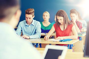 Image showing group of students with books writing school test