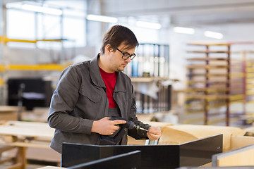 Image showing assembler with screwdriver making furniture