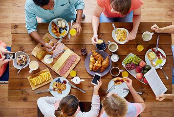 Image showing people with smartphones eating food at table