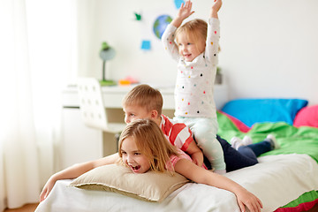 Image showing happy little kids having fun in bed at home