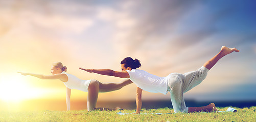 Image showing couple making yoga balancing table pose outdoors