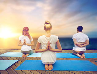 Image showing group of people doing yoga outdoors