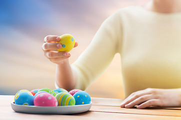 Image showing close up of woman hands with colored easter eggs