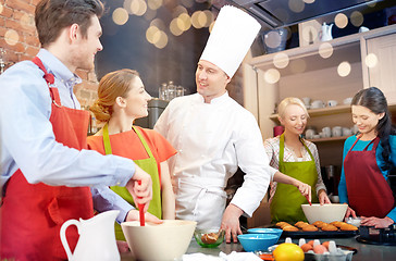 Image showing happy friends and chef cook baking in kitchen