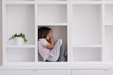 Image showing young boy posing on a shelf