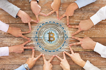 Image showing business team showing peace hand sign with bitcoin