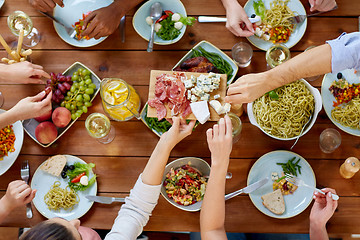 Image showing group of people eating at table with food