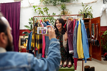 Image showing happy couple photographing at clothing store