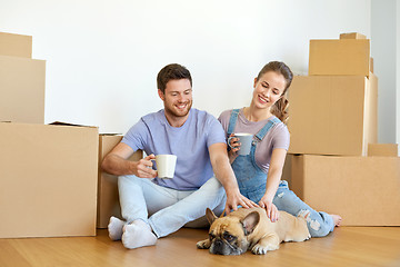 Image showing happy couple with boxes and dog moving to new home