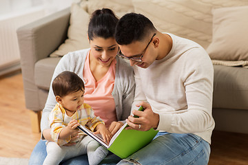 Image showing happy family with baby reading book at home