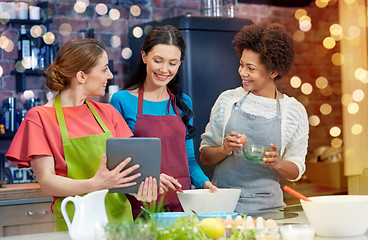 Image showing happy women with tablet pc cooking in kitchen