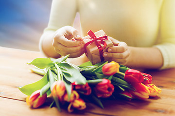 Image showing close up of woman with gift box and tulip flowers