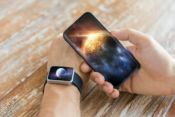 Image showing close up of hands with smartphone and smart watch