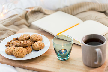 Image showing cookies, tea and candle in holder at home