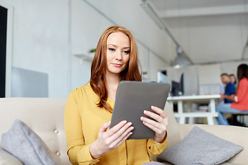 Image showing redhead woman with tablet pc working at office