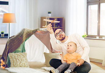 Image showing father and son playing with toy airplane at home