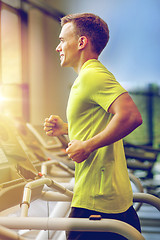 Image showing smiling man exercising on treadmill in gym