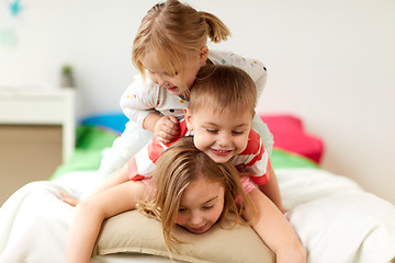 Image showing happy little kids having fun in bed at home