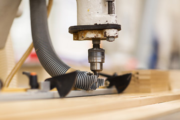 Image showing drill press machine and wooden board at workshop