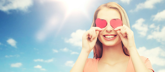 Image showing happy young woman with red heart shapes on eyes