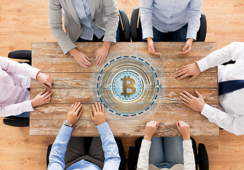 Image showing business team at table with bitcoin icon