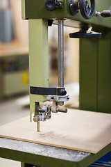 Image showing jig saw machine sawing board at workshop