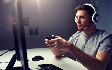 Image showing man in headset playing computer video game at home