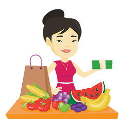 Image showing Woman standing at the table with shopping bag.